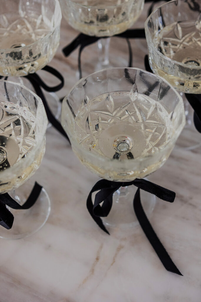 Luxury crystal champagne glasses tied with black velour ribbons at an elegant wedding reception