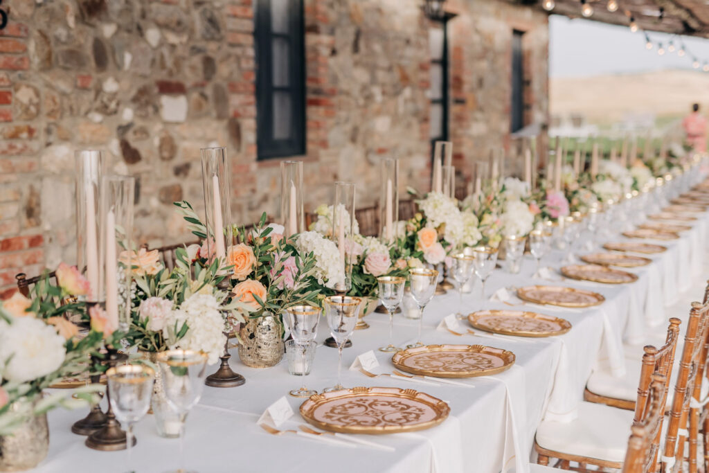 Luxury Tuscany wedding reception with long tables and elegant place settings